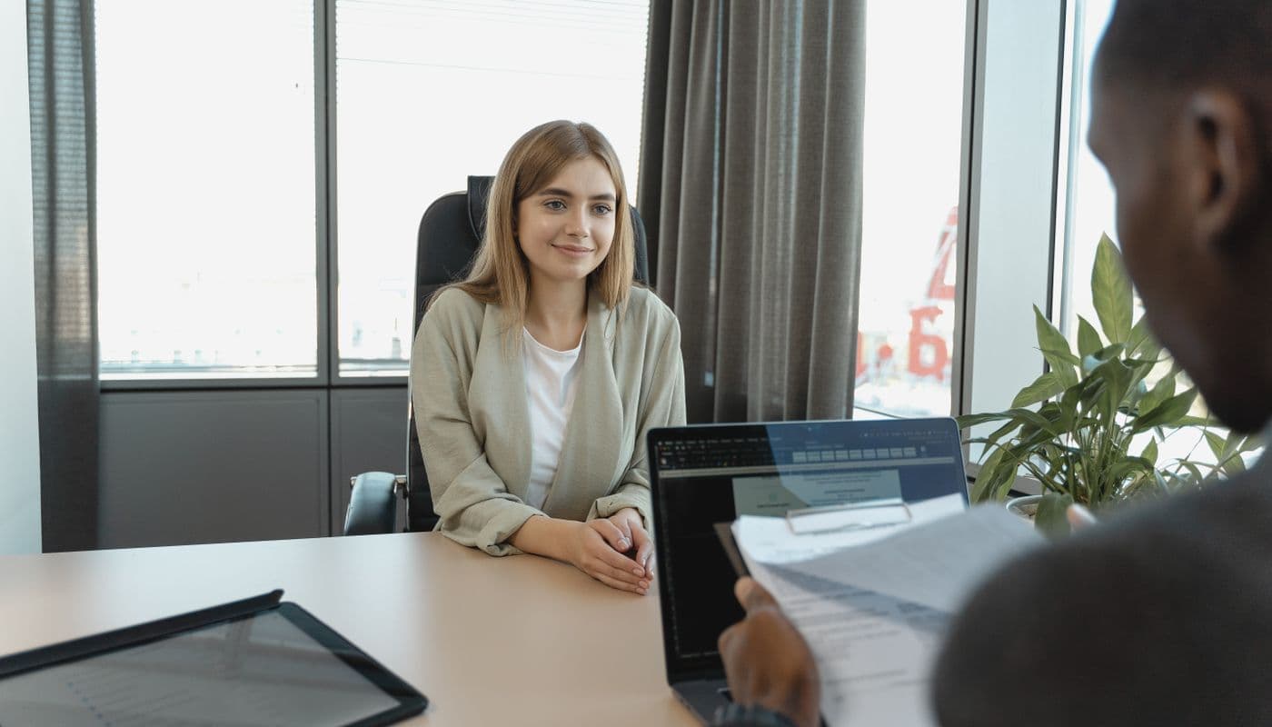 Une candidate assise face à une recruteuse lors d'un entretien d'embauche dans un bureau