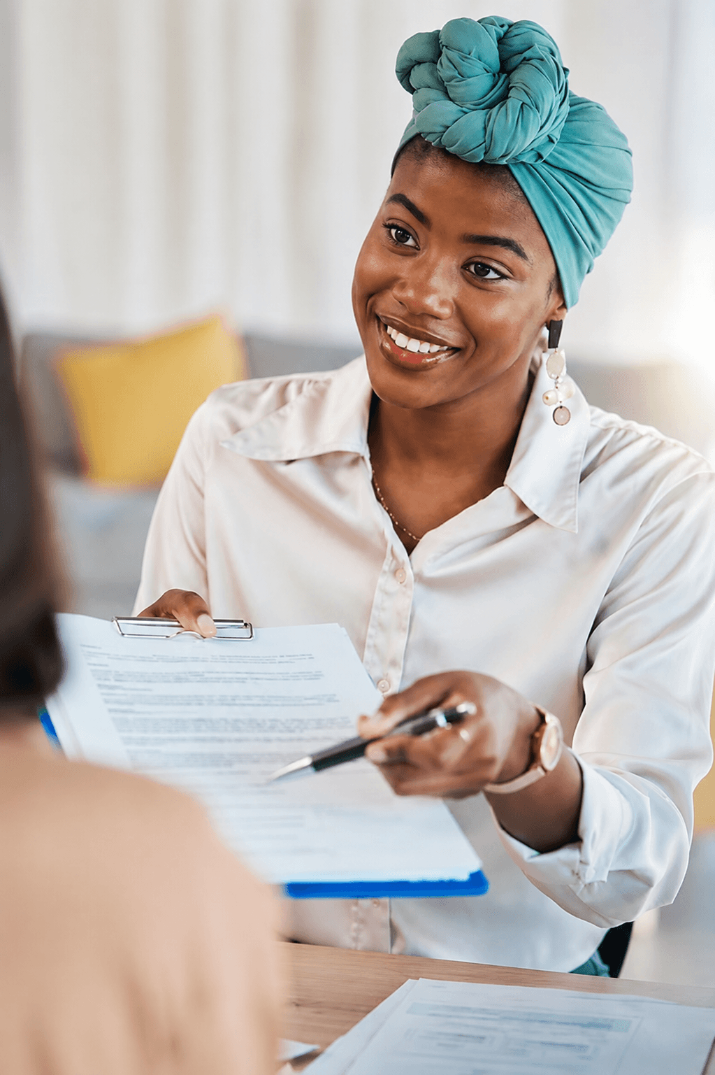 Une recruteuse tend un document à une candidate lors d’un entretien